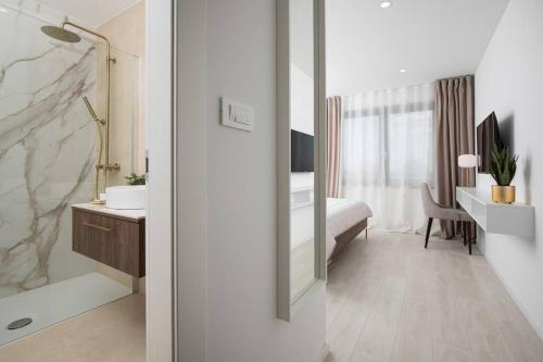 een badkamer met een wastafel, een bed en een spiegel bij Villa Artis by IstriaLux in Loborika