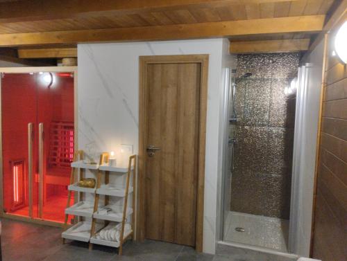 baño con ducha y puerta de madera en Vila Carmen Holiday mountain house With jacuzzi and sauna, en Mrkopalj