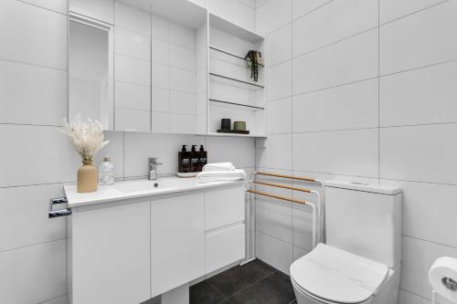 a white bathroom with a toilet and a sink at Bev's Retreat by Ready Set Stay in Melbourne