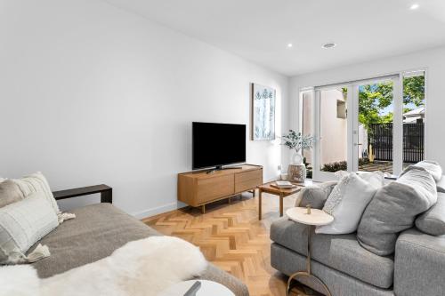 a living room with a couch and a flat screen tv at Bev's Retreat by Ready Set Stay in Melbourne