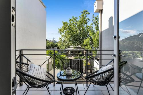 a balcony with two chairs and a glass table at Bev's Retreat by Ready Set Stay in Melbourne