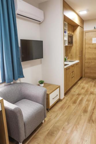 a living room with a couch and a kitchen at Grand Park rooms & apartments in Čačak