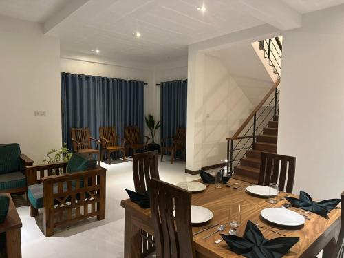 un comedor con mesa y sillas y una escalera en SOHA Home Stay en Galle