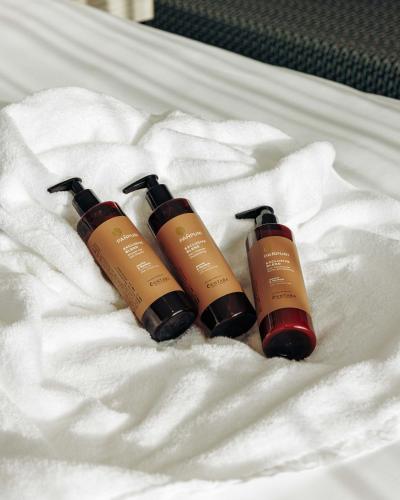 three shampoo bottles sitting on top of a bed at Centara Grand Hotel Osaka in Osaka