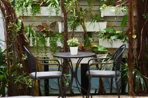 a table with four chairs and a table with a plant at Villa Labaron in Koh Samui 