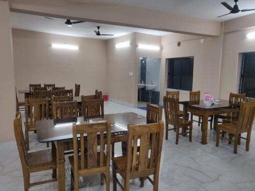 a dining room with wooden tables and chairs at ICHHAMATI HOTEL AND RESTAURANT in Hāsnābād