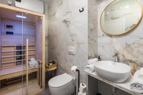 a bathroom with a sink and a toilet and a mirror at Area1 Center Luxury Apartment with sauna in Rijeka