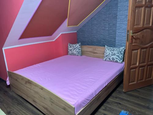 ein kleines Bett in einem Zimmer mit einer Treppe in der Unterkunft BRC Hostel & Car Rent Budapest in Budapest