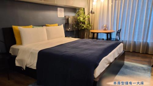 a bedroom with a large bed and a table at Yomi Hotel - ShuangLian MRT in Taipei