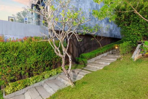 een trap naar een gebouw met een boom bij Romantic villa in the tropics near Kamala Beach in Kamala Beach
