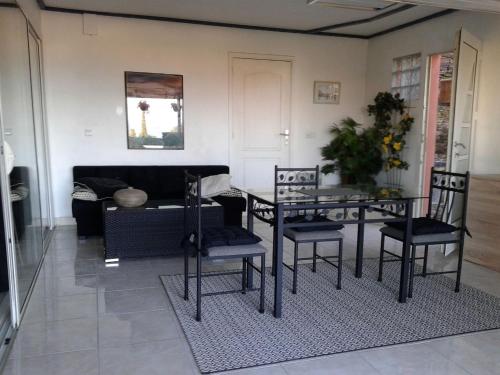 un salon avec une table et des chaises de salle à manger dans l'établissement roxane Appartement F1 Bis Face La Mer, à Collioure
