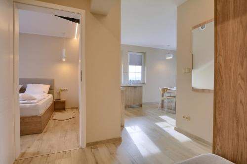 a bedroom with a bed and a room with a table at Jagodowy Ski&Spa DeLux apartamenty z widokiem na góry,4km od Zieleniec Ski Arena Podgrzewany basen zewnętrzny latem,bilard,Wi-Fi w cenie Restauracja,balia,sauna na miejscu in Lasowka