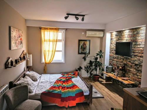 1 dormitorio con 1 cama con una manta colorida en Natura Apartment 2, en Ledine