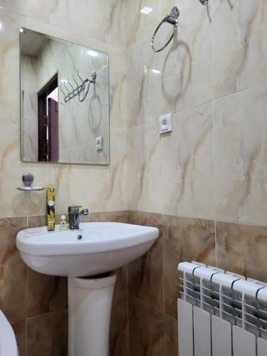 W łazience znajduje się umywalka i lustro. w obiekcie Dili Orom Hotel w mieście Buchara