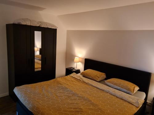 een slaapkamer met een bed met 2 kussens en een spiegel bij T Karraet in Maasmechelen