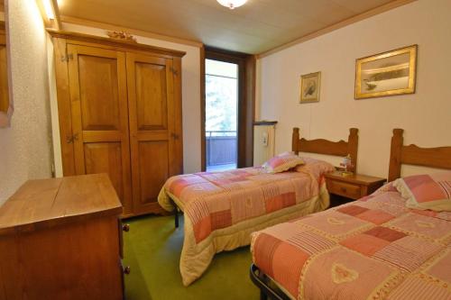 a hotel room with two beds and a window at Capanna Arnold Apartment in Madonna di Campiglio