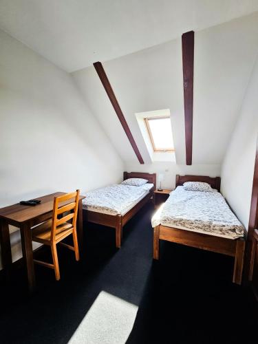 a room with two beds and a table and a window at Gościniec Gryszczeniówka & SPA in Wargowo