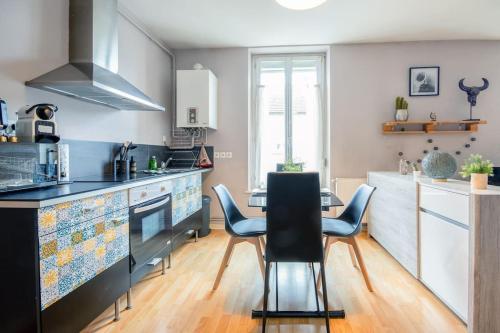 uma cozinha com mesa e cadeiras num quarto em Le Gambetta 