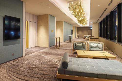 大阪市にあるCentara Grand Hotel Osakaのソファとテレビ付きのホテルロビー