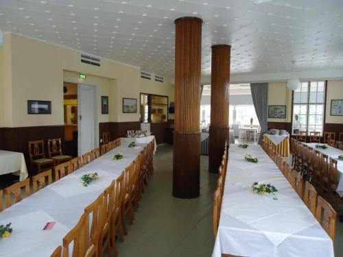 a banquet hall with long tables and chairs at Mäntyluodon Hotelli in Pori