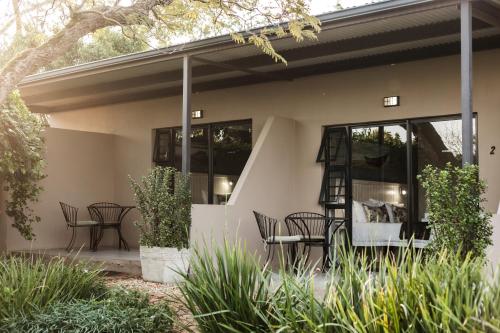 a house with chairs and tables on a patio at Bona Vista Self-Catering Accommodation in Klapmuts