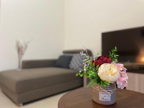 a jar of flowers on a table in a living room at Jiu Xingji in Dayin
