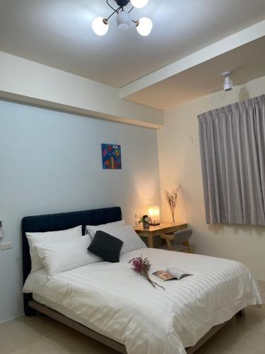 a bedroom with a large white bed with a blue headboard at Jiu Xingji in Dayin