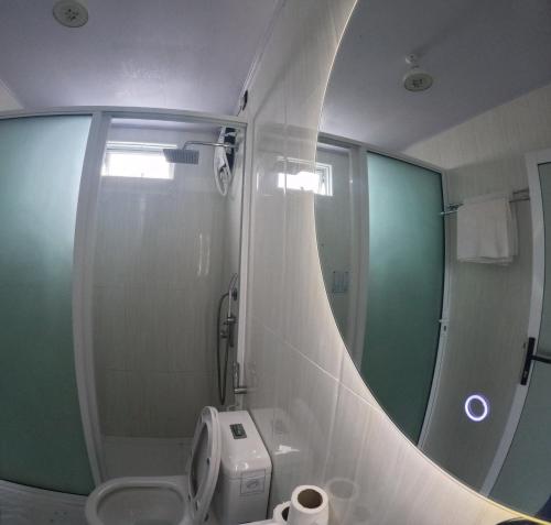 a bathroom with a mirror and a sink and a toilet at Wind Breeze Sunset View Inn in Guraidhoo