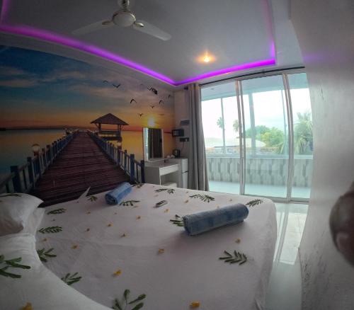 a bedroom with a bed with a view of a pier at Wind Breeze Sunset View Inn in Guraidhoo