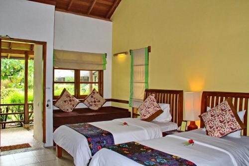 Cocotinos Manado في مانادو: غرفة فندقية بسريرين وبلكونة