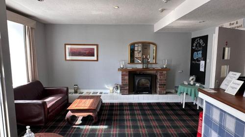 a living room with a couch and a fireplace at The Bruce Hotel in Newton Stewart