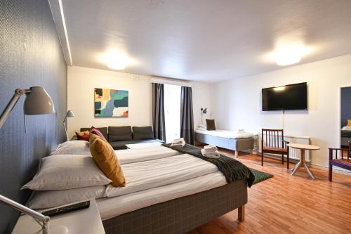 a bedroom with a large bed and a living room at Prins Carl in Ystad