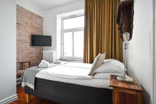 a bedroom with a large bed in a room with a window at Prins Carl in Ystad