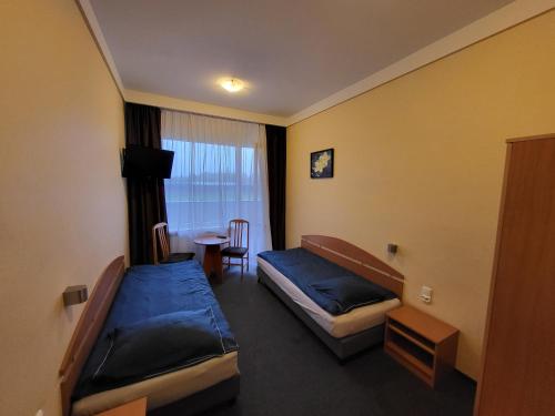 a hotel room with two beds and a table at Hotel Parkowy in Malbork