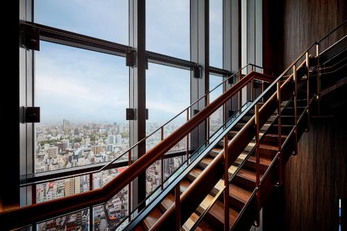 a staircase in a building looking out at a city at Centara Grand Hotel Osaka in Osaka