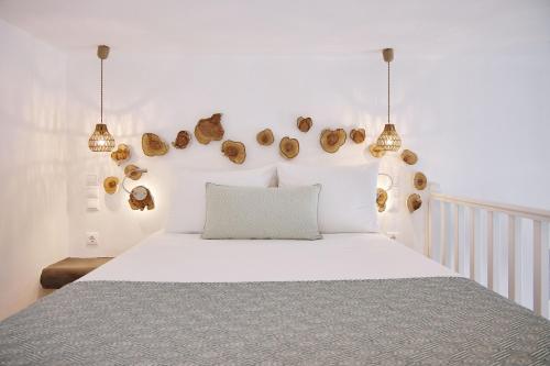 a bedroom with a white bed and two lights at Chrysalis Boutique - Adults Only in Astypalaia Town