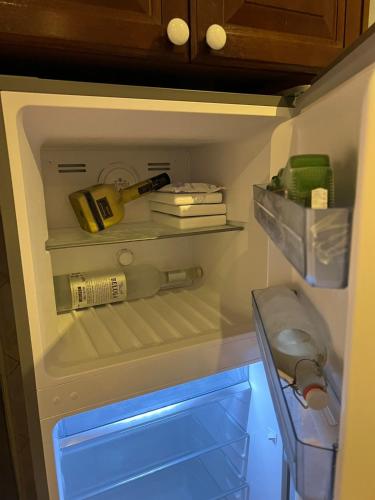 an open refrigerator with a bottle of wine and a shelf at Villa Sol Luxury Costa Brava Golf in Peralada