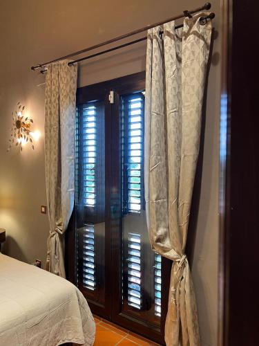 a bedroom with a bed and a window with curtains at Villa Sol Luxury Costa Brava Golf in Peralada