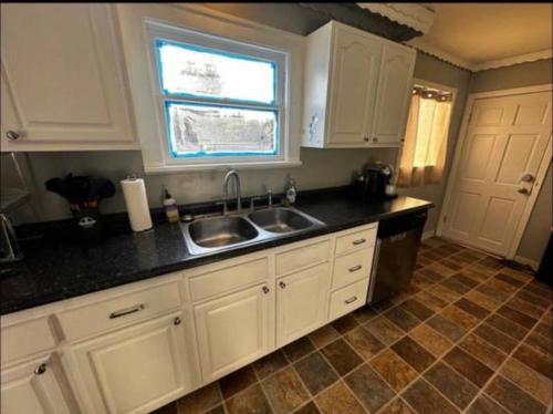 塔科馬的住宿－Tacoma Homestay- With Breakfast Included-Private Room，厨房配有白色橱柜、水槽和窗户。