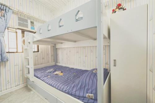 a bedroom with a bunk bed with purple sheets at apt 4BR10pax, 2bar ,1mins mtr in Hong Kong