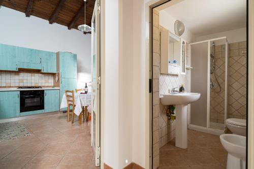 uma casa de banho com um lavatório e um WC num quarto em La casa del sole em Loculi