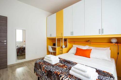 Schlafzimmer mit einem Bett mit weißen und orangefarbenen Kissen in der Unterkunft Moderno Spazioso e a 2 passi dal Lago in Longone al Segrino