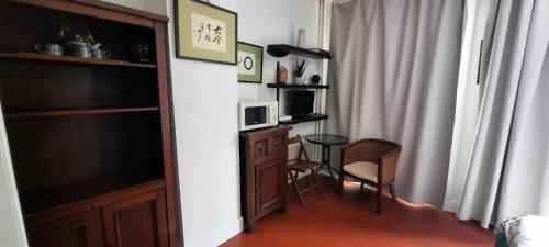 Cette chambre dispose d'un bureau, d'un four micro-ondes et d'une télévision. dans l'établissement Studio Rue st Martin, à Paris
