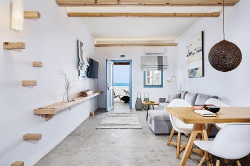 a living room with white walls and a table and chairs at Chrysalis Boutique - Adults Only in Astypalaia Town