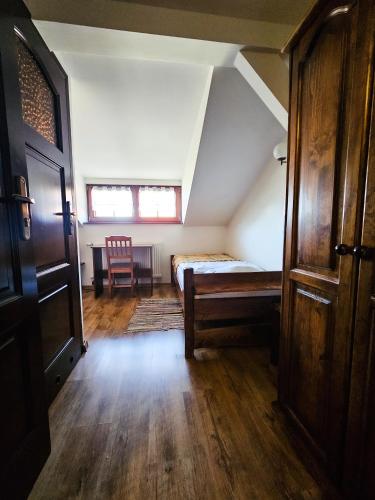 an attic room with a bed and a table at Gościniec Gryszczeniówka & SPA in Wargowo