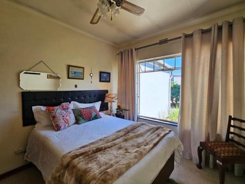 ein Schlafzimmer mit einem großen Bett und einem Fenster in der Unterkunft Alberton Africa Away in Alberton