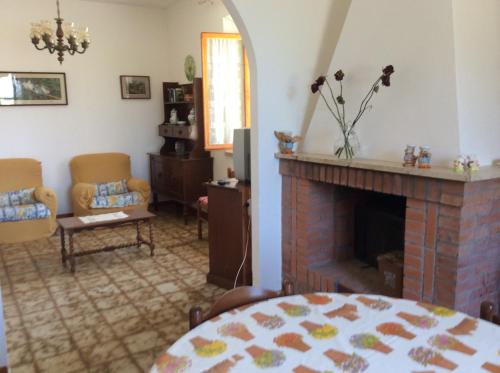 a living room with a fireplace and a table and chairs at Agriturismo Susanna e Atria in Bibbona
