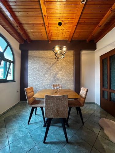 a dining room with a wooden ceiling and a table and chairs at Apartman Tóth György in Bačka Topola