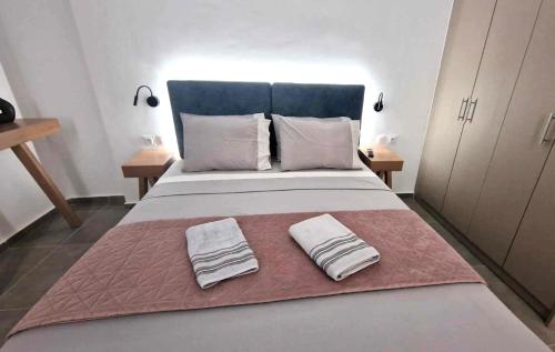 a bedroom with a large bed with two towels on it at Vv Cosy Host 2 in Larisa