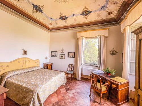 1 dormitorio con cama, escritorio y ventana en Prestigious manor with pool, air conditioning, en Monte Campano